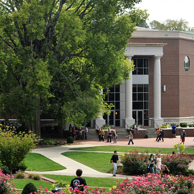 The front of Beaman Student Life Center with students walking in front on a sunny day