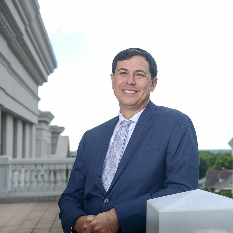 An adult degree student standing on a balcony