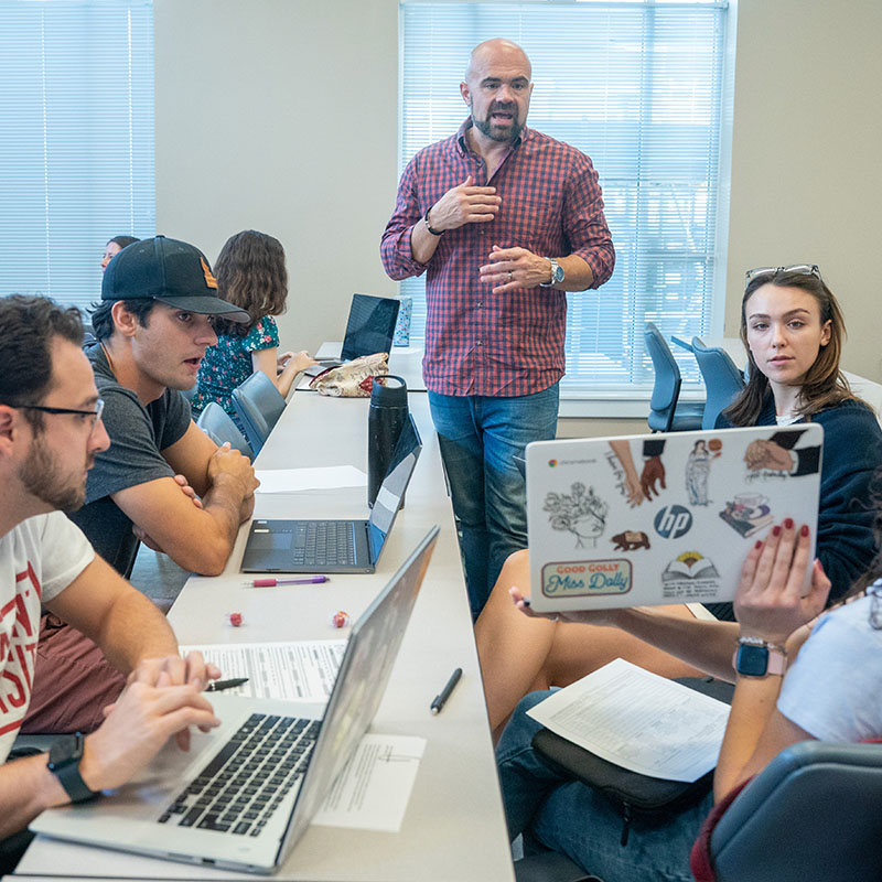 A professor talking with students in a class