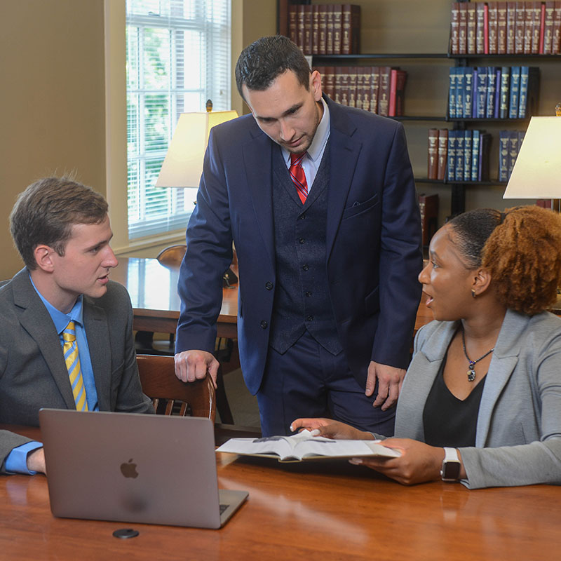 three law students studying the law library. 