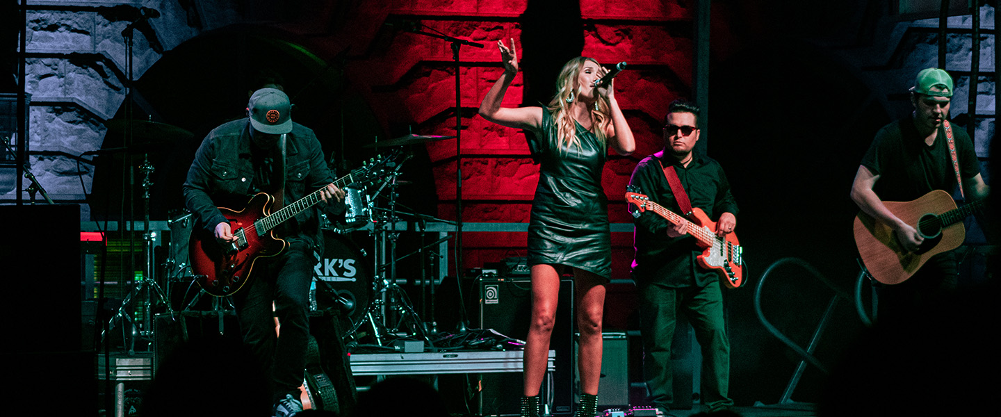 A female student sings in front of her band.