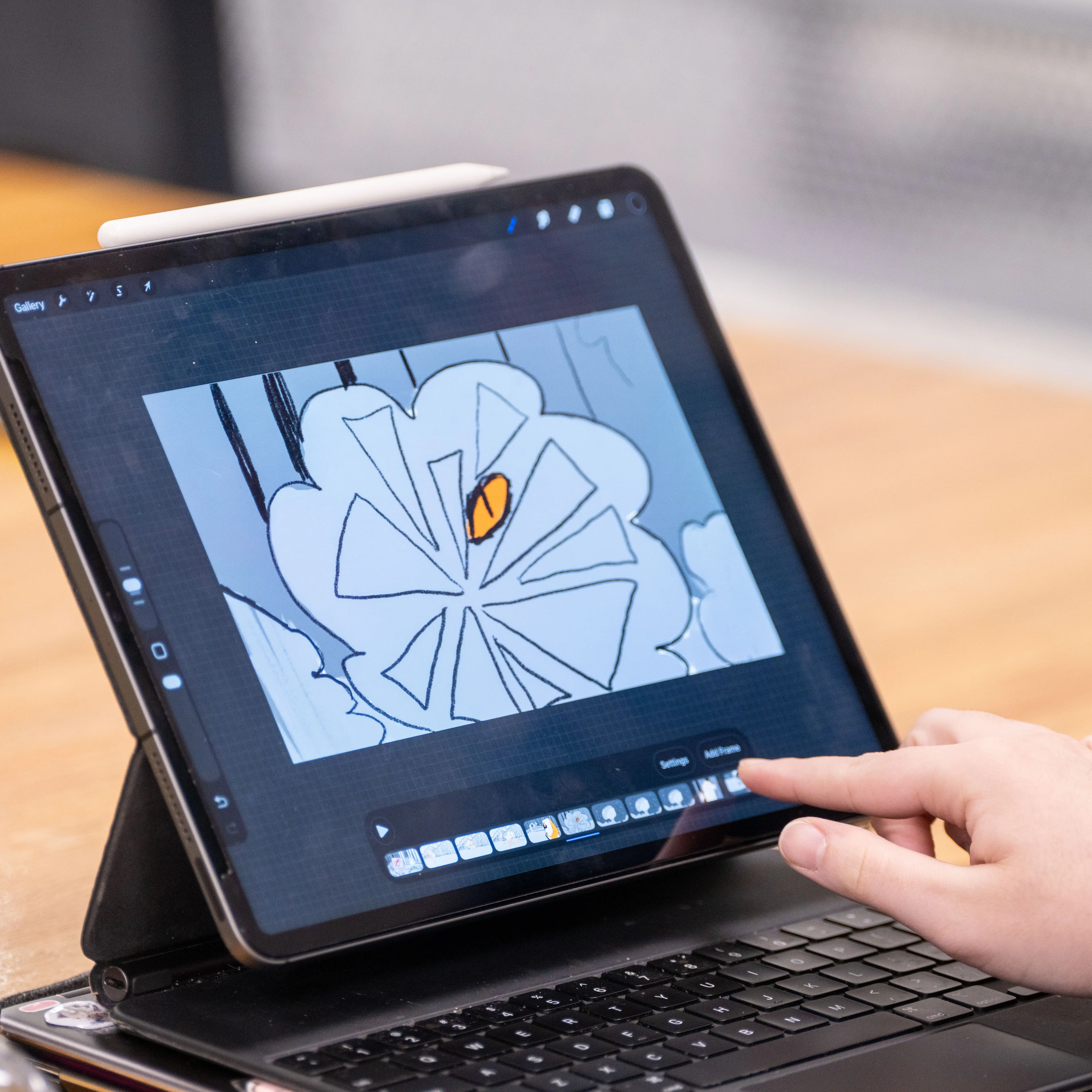 A student creates a digital animation on a tablet, using professional drawing software to develop artwork and animate individual frames.