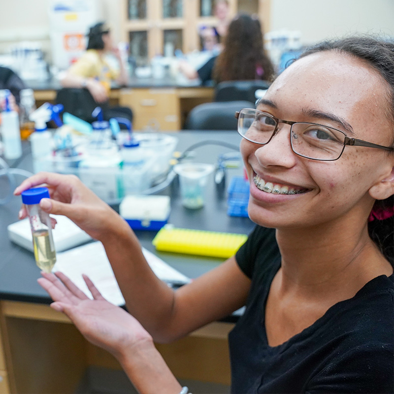 Student holding up text tube for picture