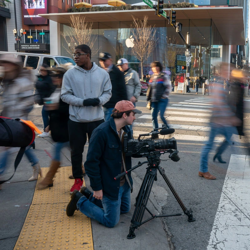 A student filming in a city