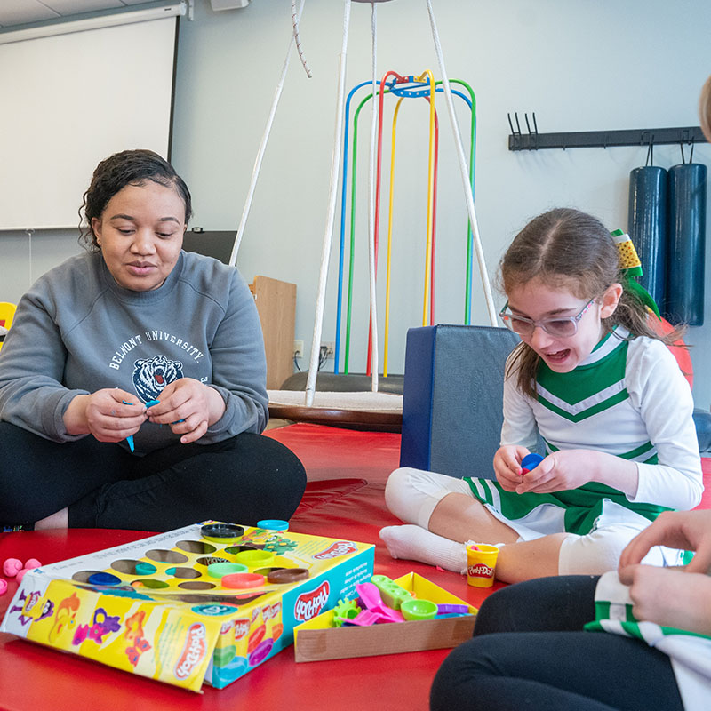 An occupational therapy student works with a child during an exercise