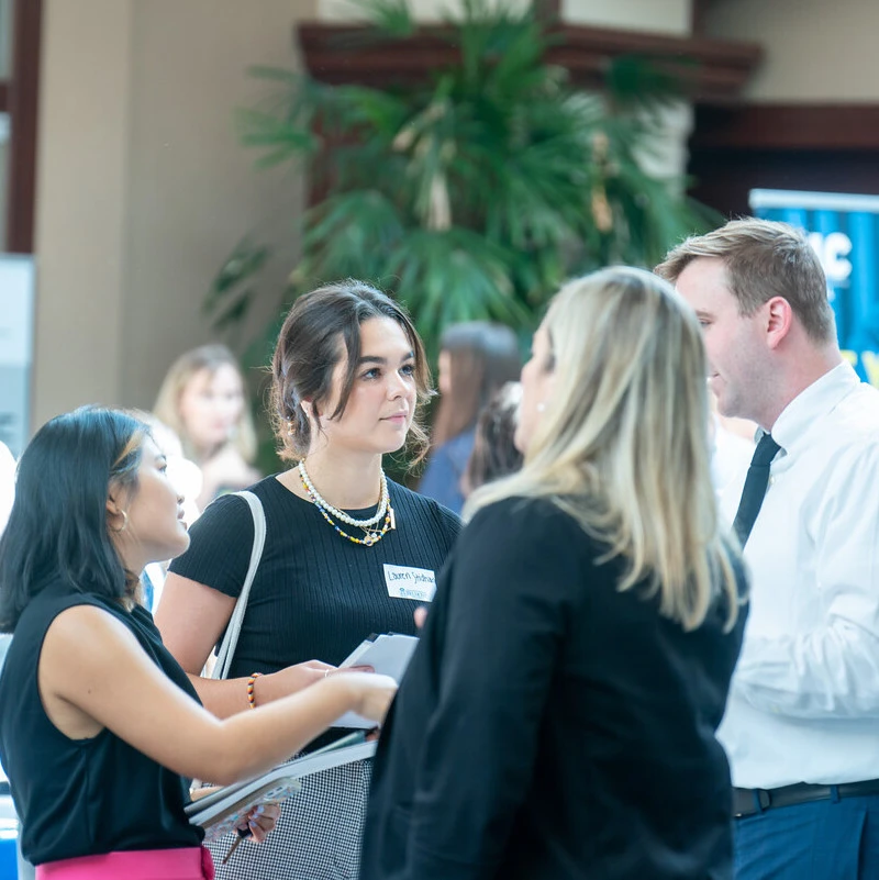 Student talking with potential employers at job fair