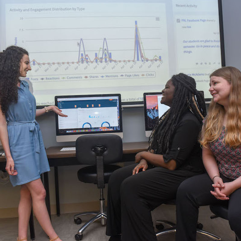 Students having small group discussion in front of computers