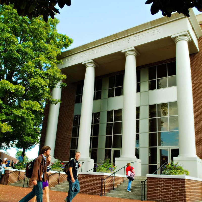 Exterior shot of the Beaman Student Life Center on a sunny day while student walk to class in front of the building