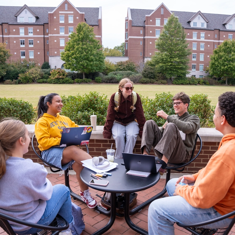 image of students sitting outside at a table between classes