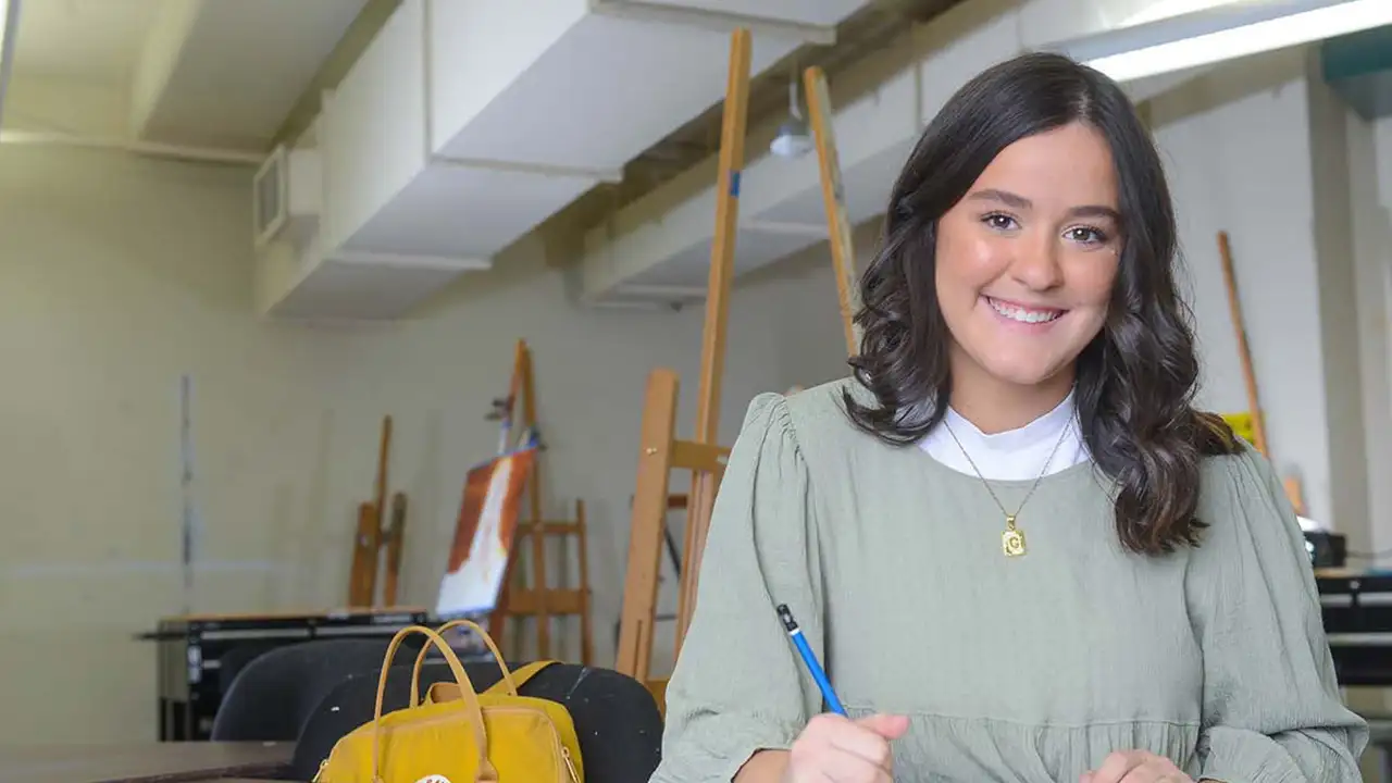 Carrie Neville sitting in an art classroom