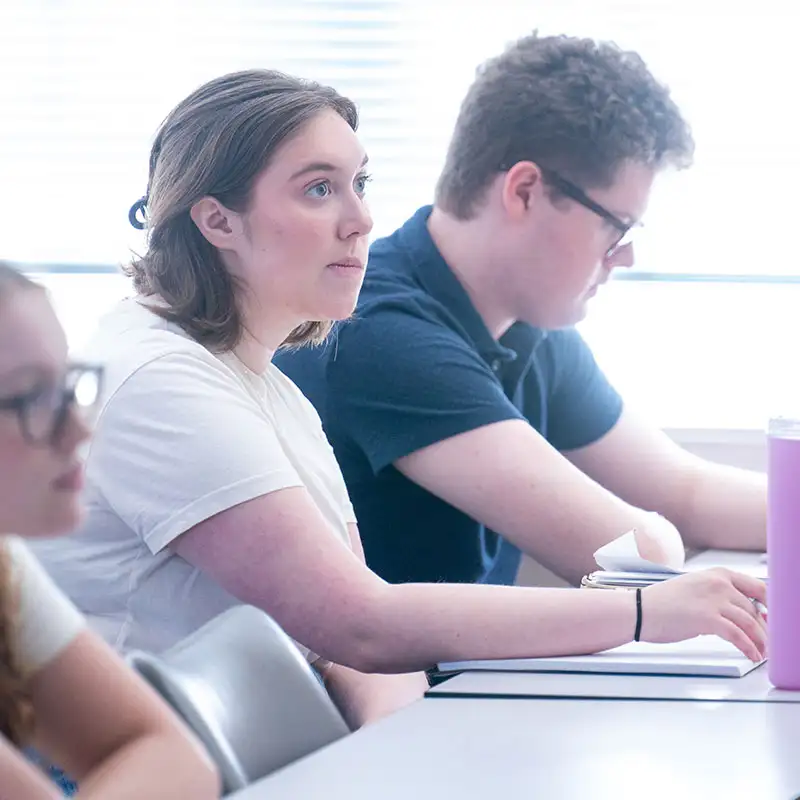 A student listening to a professor during a Journalism Class