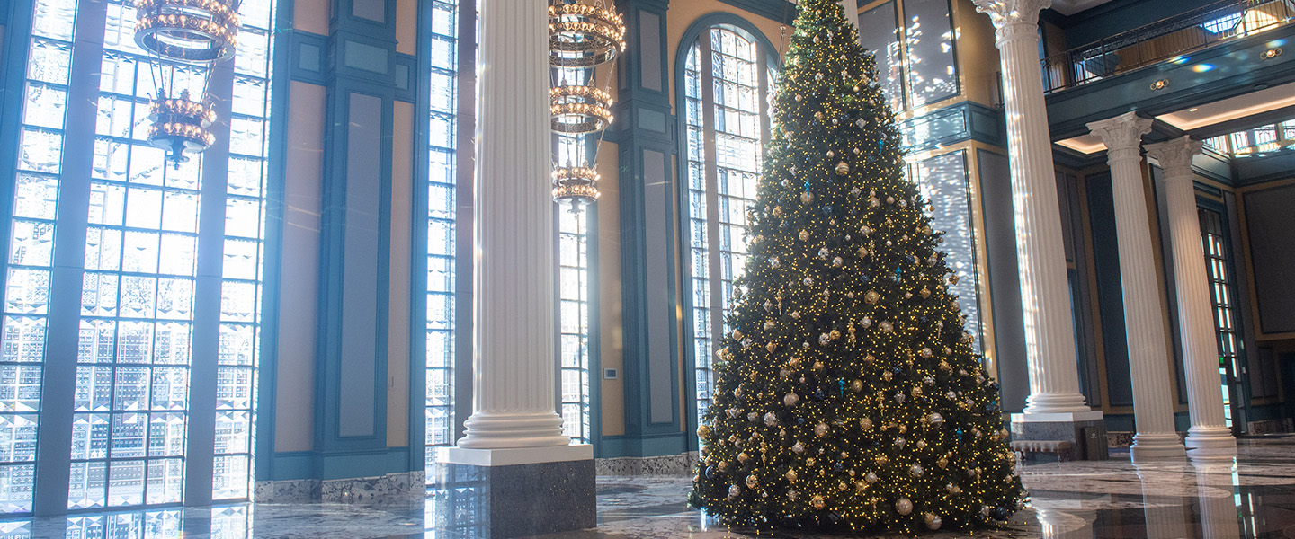 Christmas tree in the lobby of the Fisher center surrounded by columns and marble floors