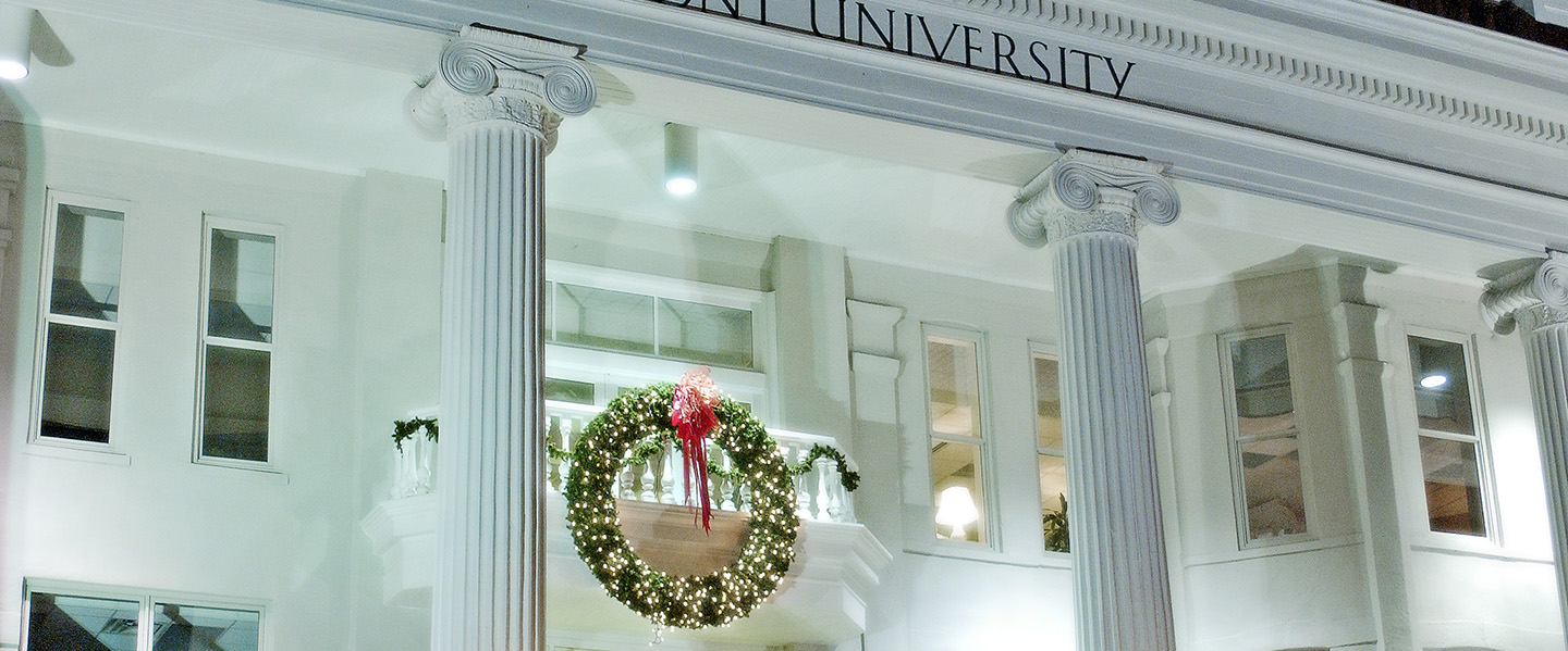 White Belmont University building with columns and Christmas wreath