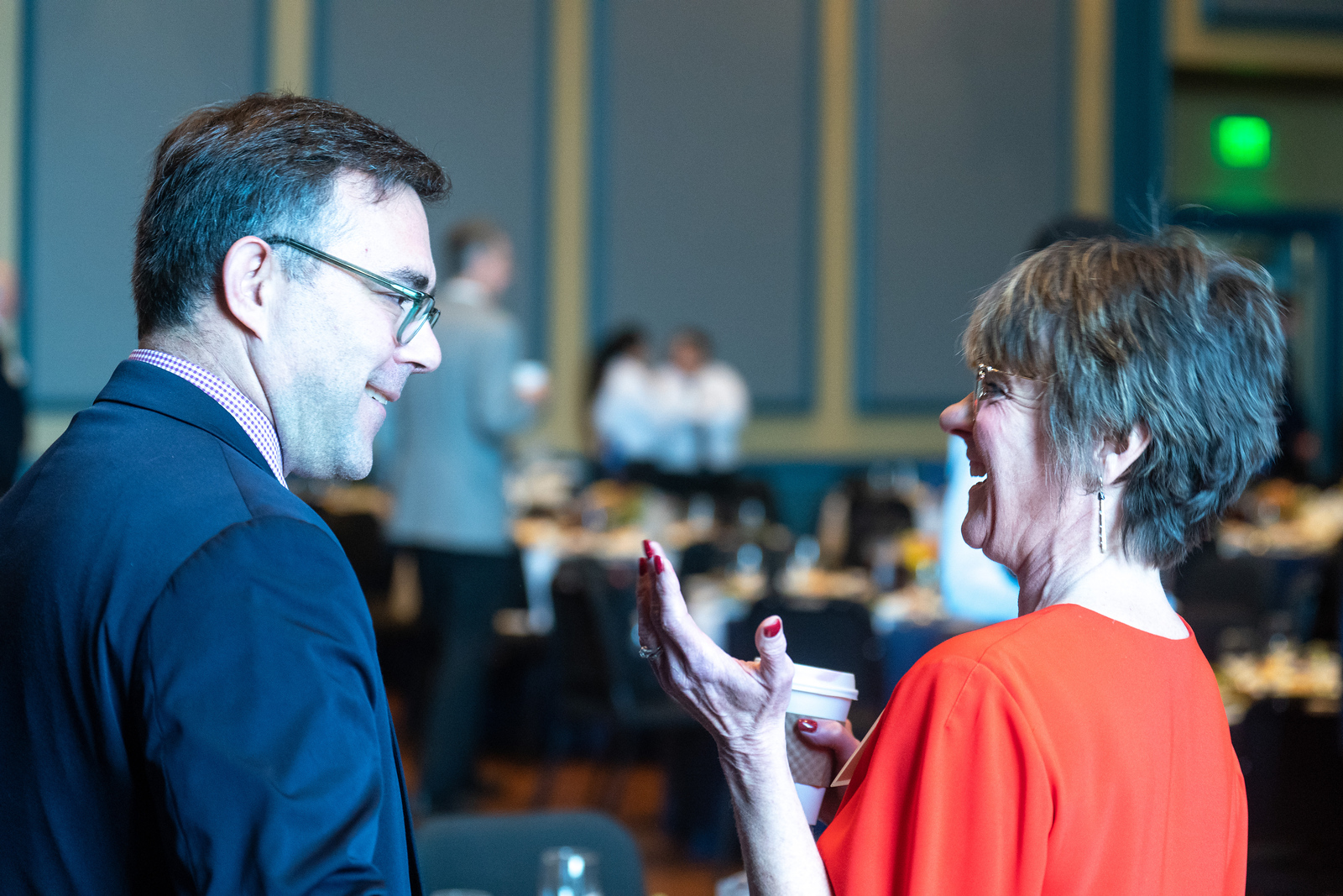 A man and woman talk at a Belmont networking event.