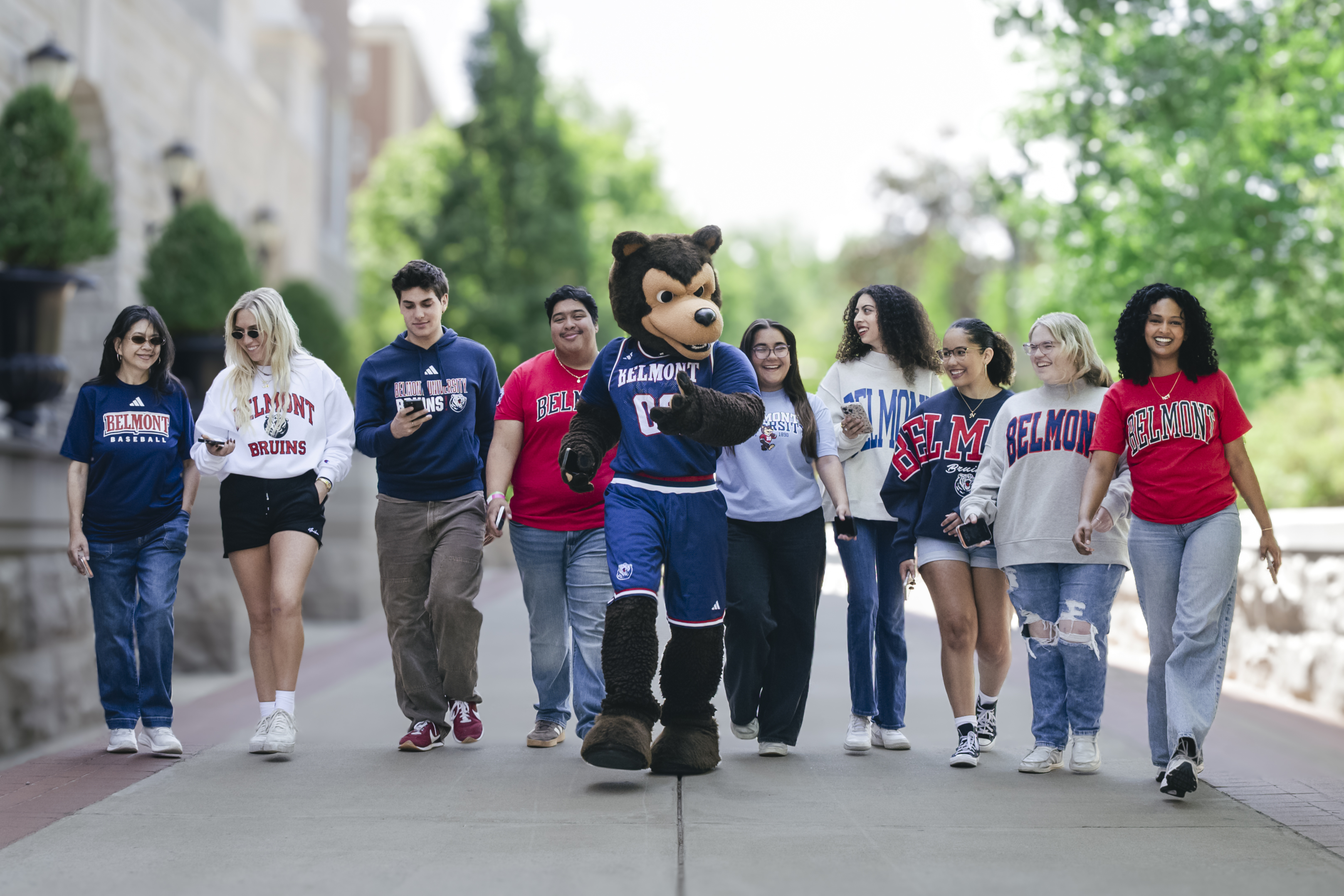 Bruiser and students holding mobile devices walking toward camera 