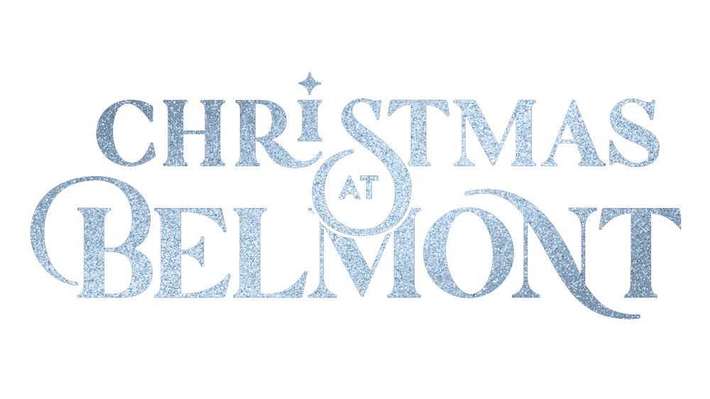 A large choir of Belmont University students performs on stage during the Christmas at Belmont concert, held in the Fisher Center for the Performing Arts. The singers are dressed in festive attire, with a mix of red, green, and black dresses and suits. They stand in a long row at the front of the stage, illuminated by vibrant stage lights.