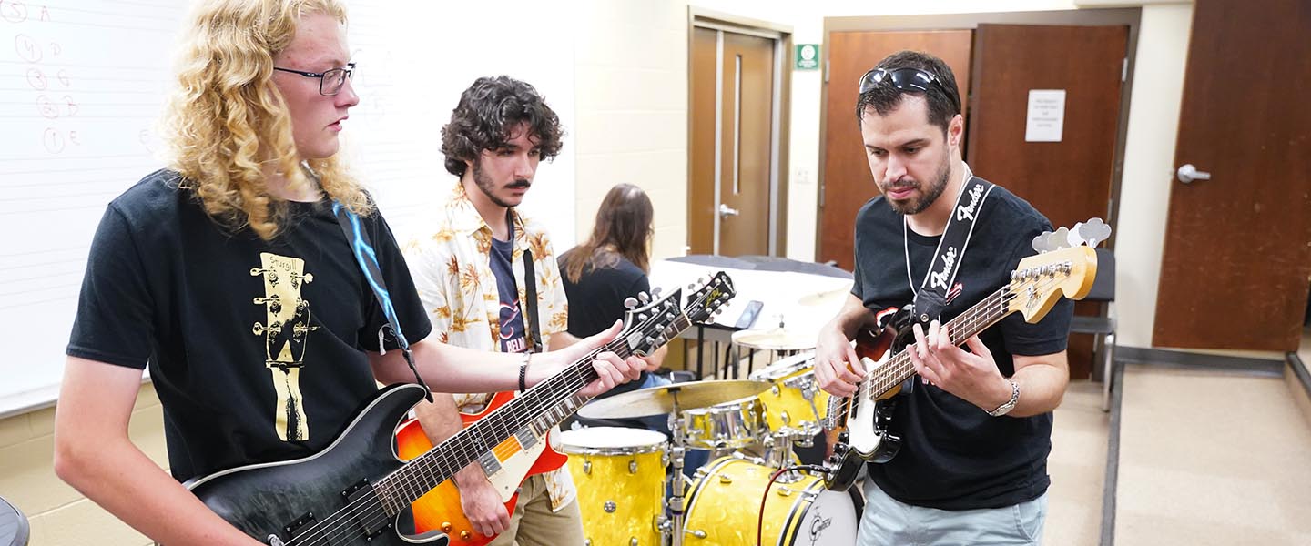 Guitar professor teaches guitar to students