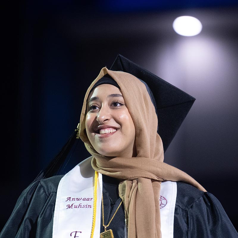 Close up of graduate walking across stage to accept diploma