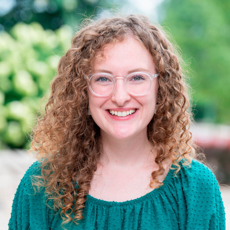 Image of Kay Tally in a teal blouse against a natural background