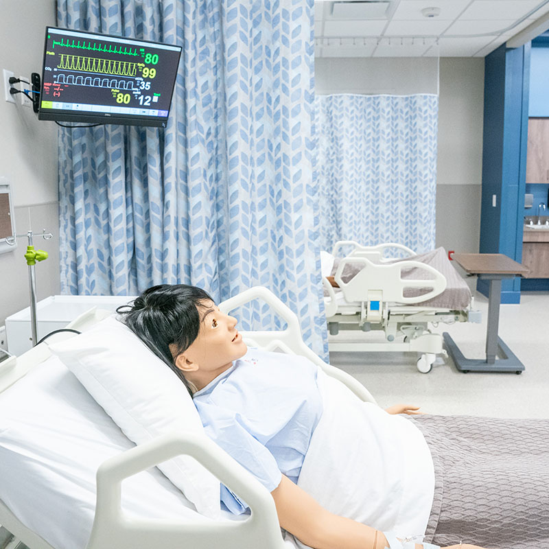 Close up of Hospital bed simulation lab with medical training dummy in the bed