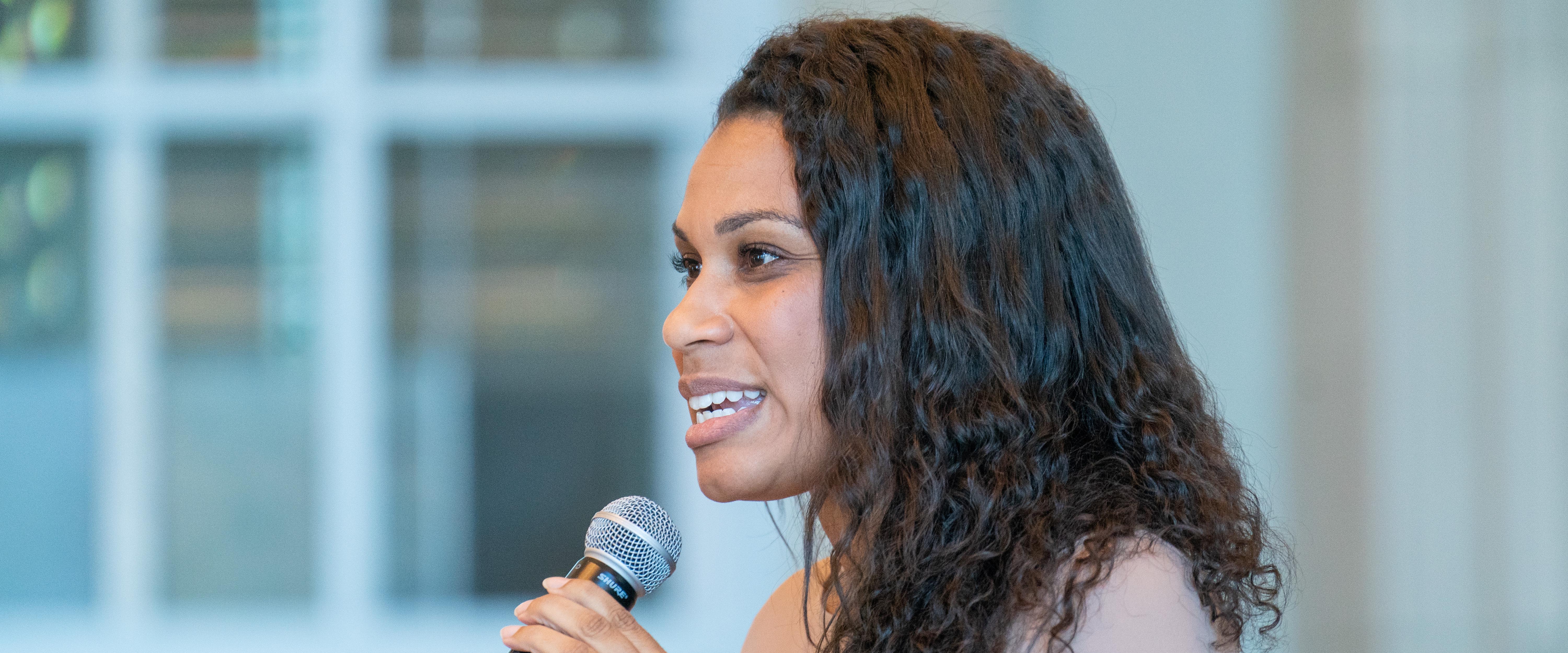 A woman speaking into a microphone during chapel speaker discussion