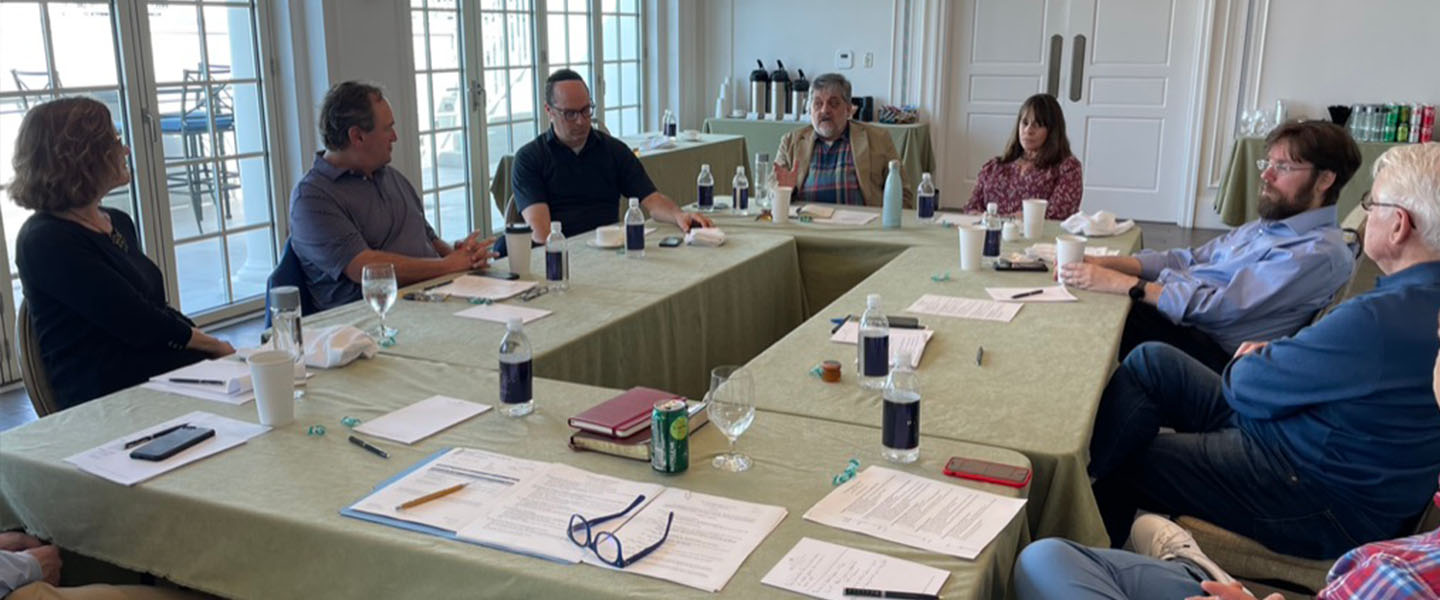 A group of people sitting around a table having a discussion