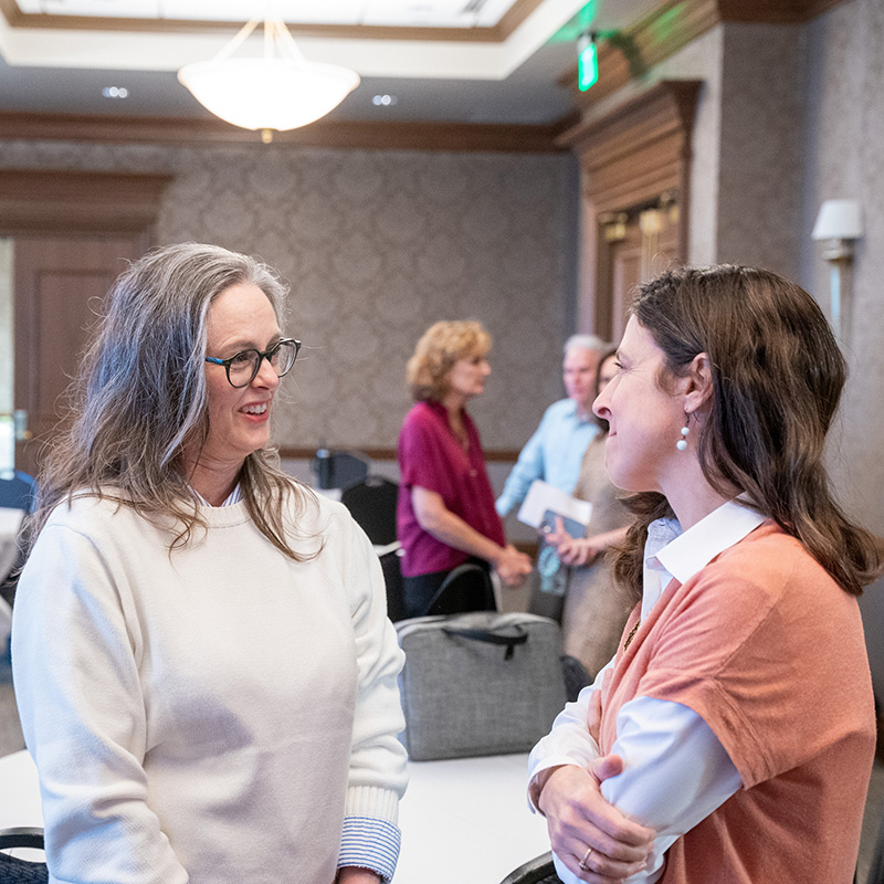 Two women smiling and talking during RiseStrong
