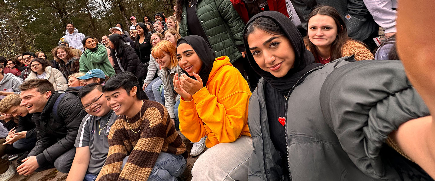 A student takes a photo of herself in a large group of students at a leadership development event