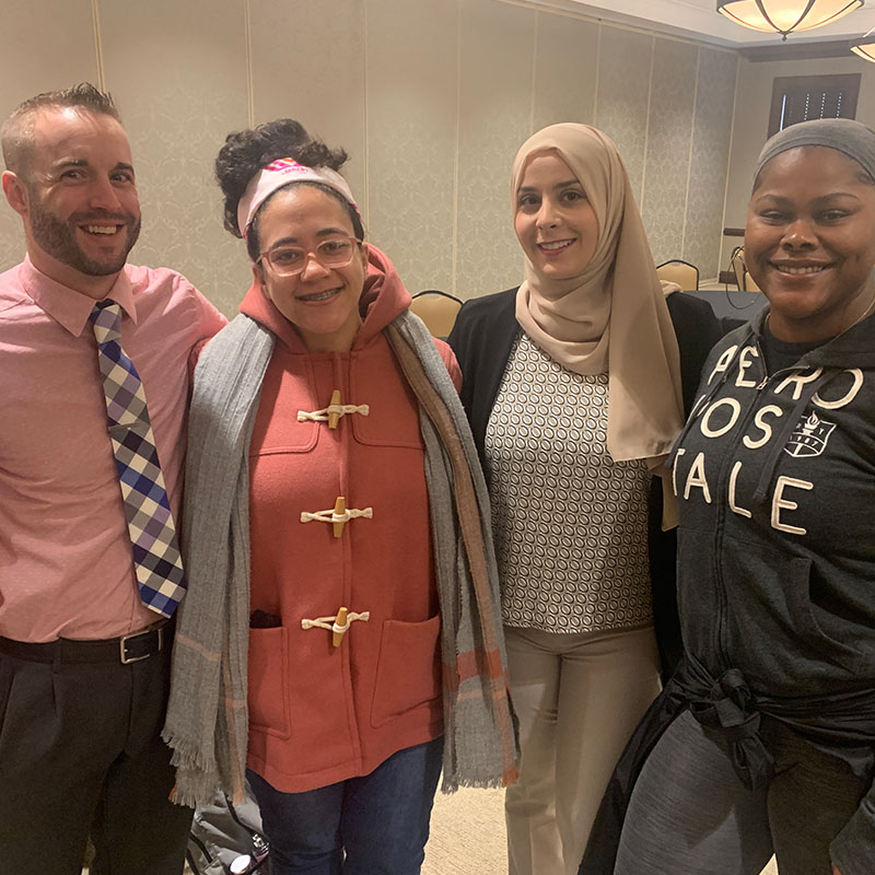 Four graduate students posing for a photo at a GOLD event