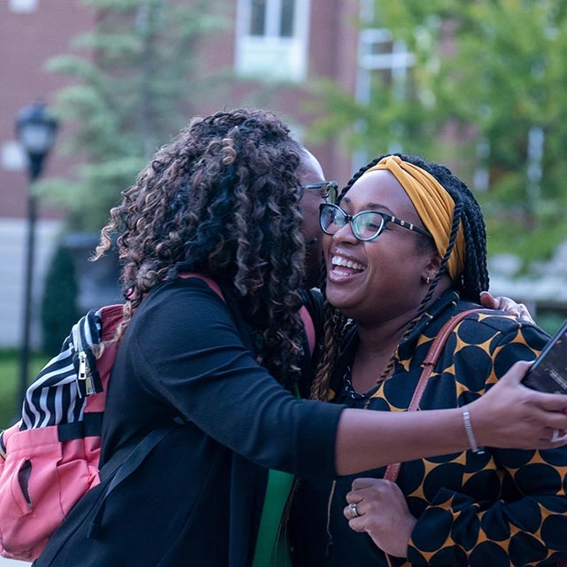 Two women hugging outside in freedom plaza