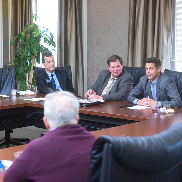 The Advisory Board sitting at a conference table