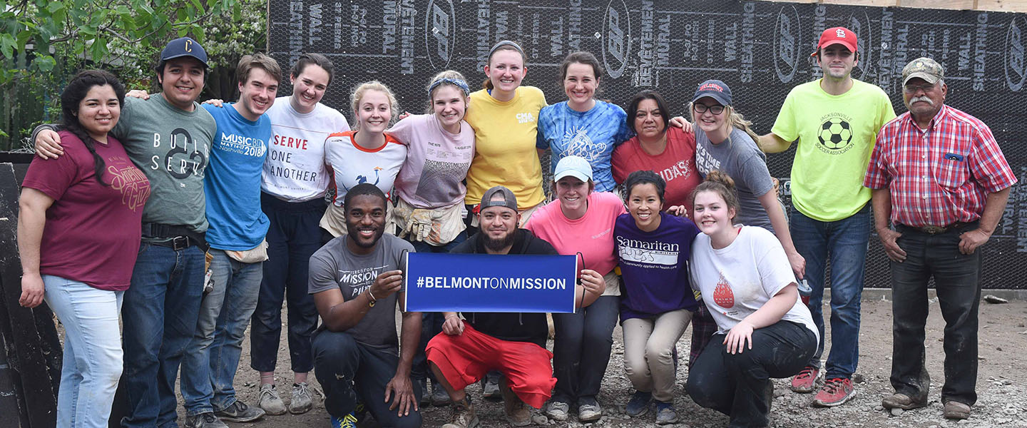 A group of students stands with a "Belmont on Mission" sign.