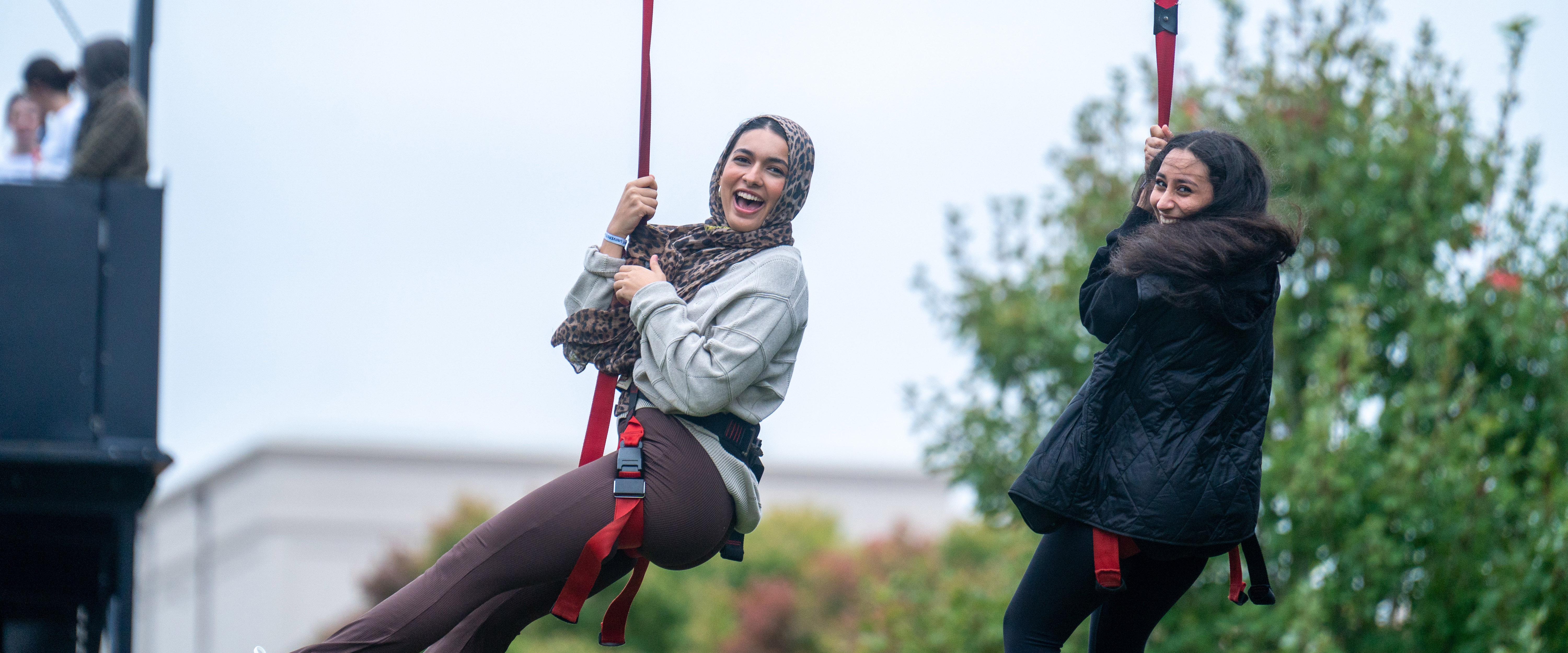 2 students riding zip line at Belmont's day to dream