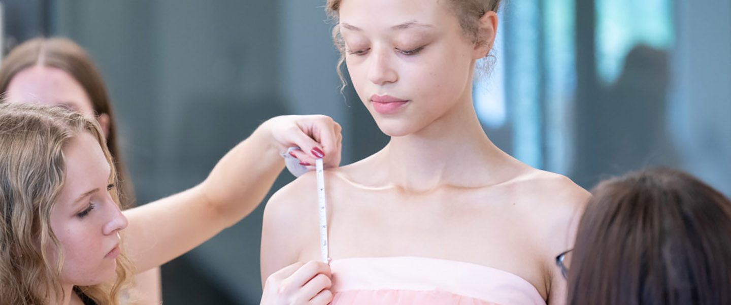 Fashion student measuring a model during a fitting