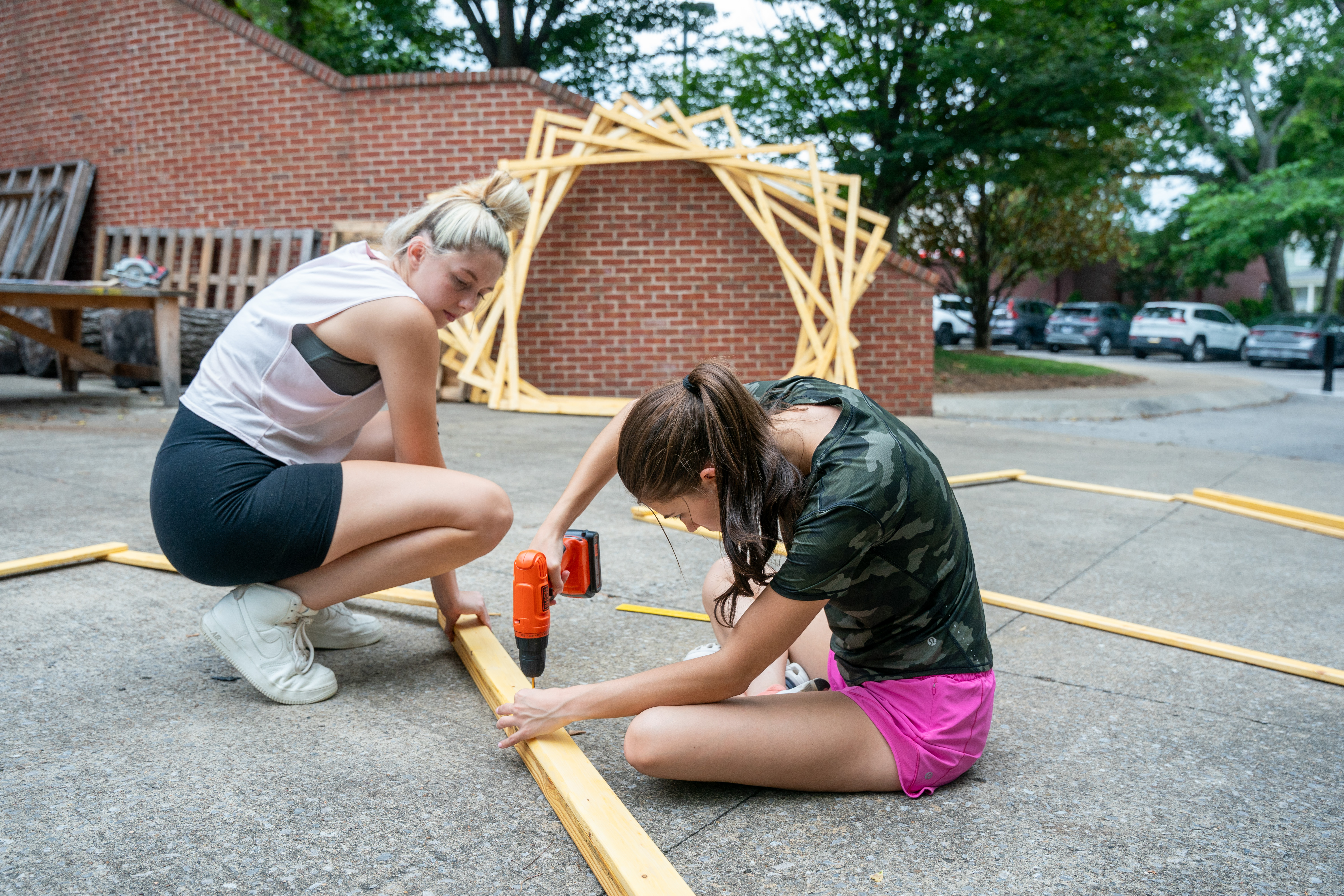 A picture of two women screwing two boards together