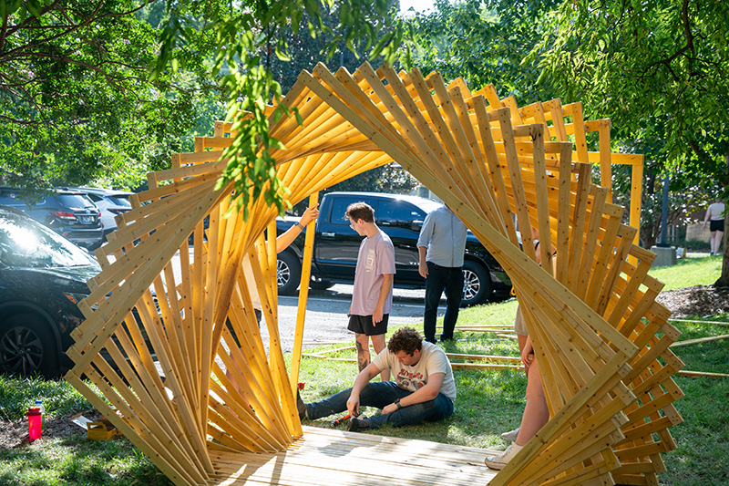 Students working on creating a wooden pavilion