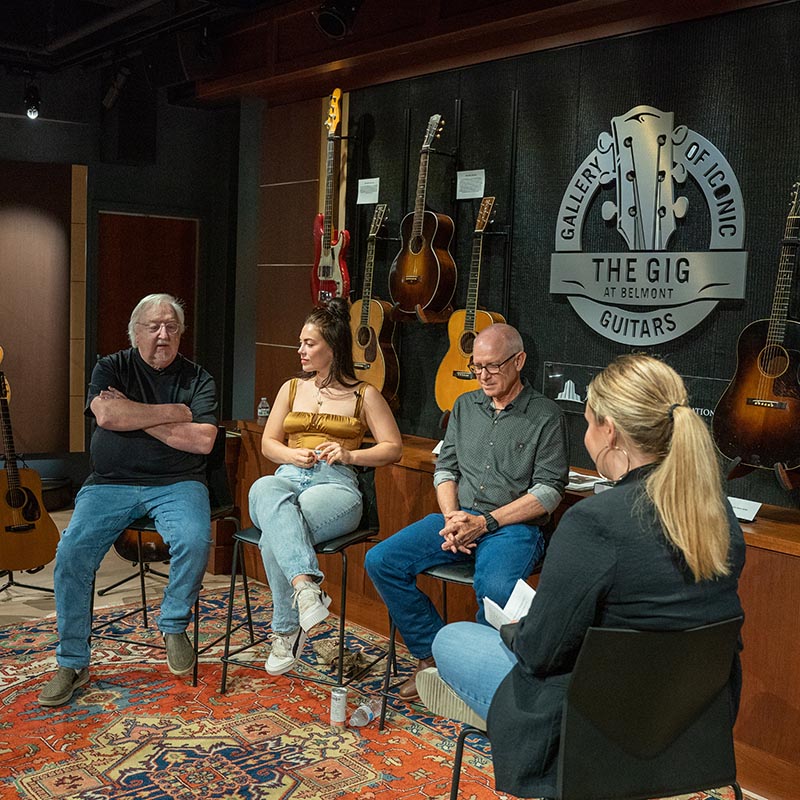 Teachers and guest sit on stools during songwriting class in the gig museum 