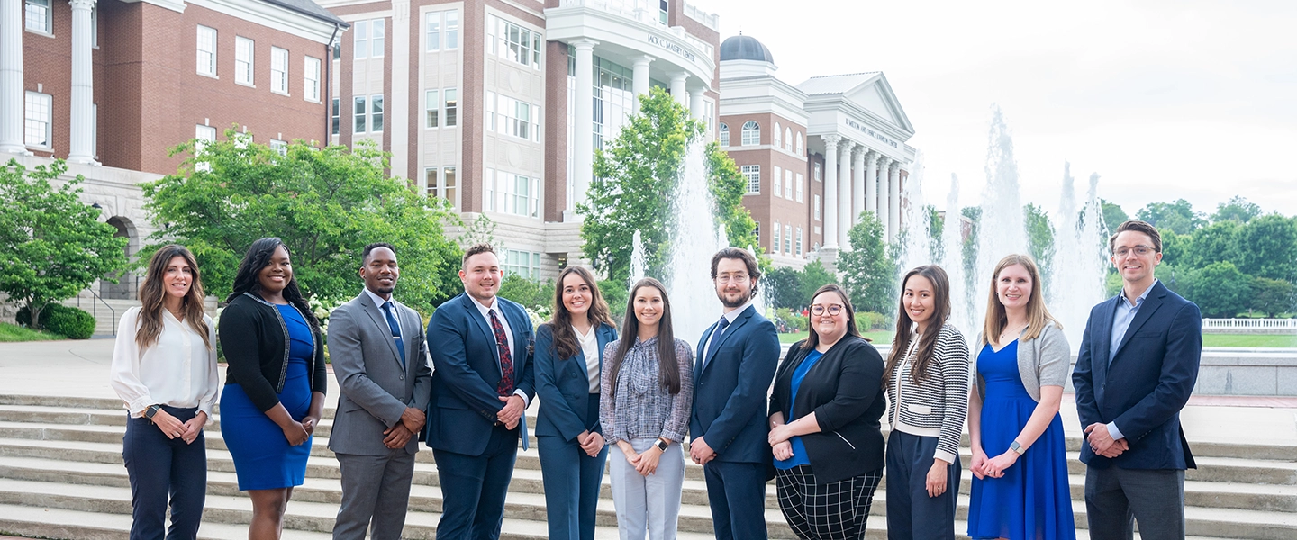 Pharmacy Fellows pose for a photo outside in front of a Belmont university fountain.