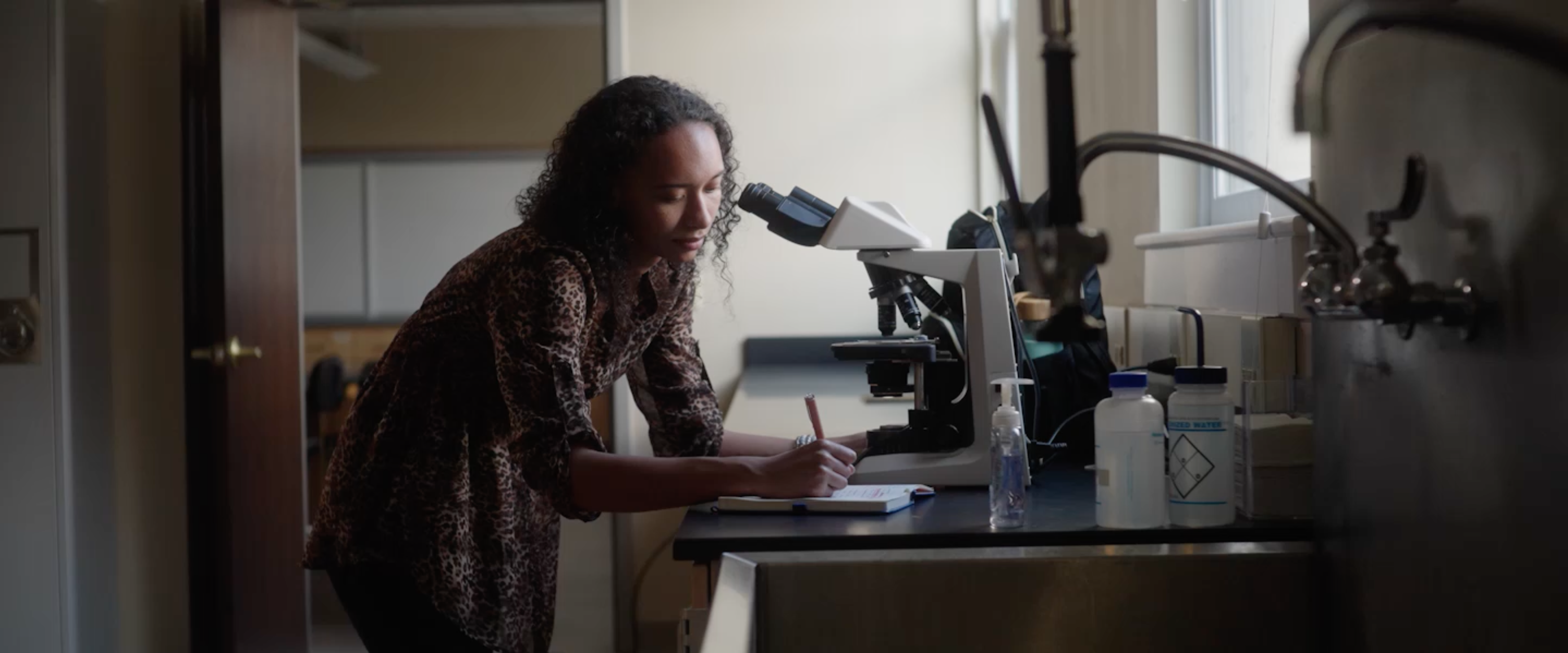 Science student using microscope for scientific research