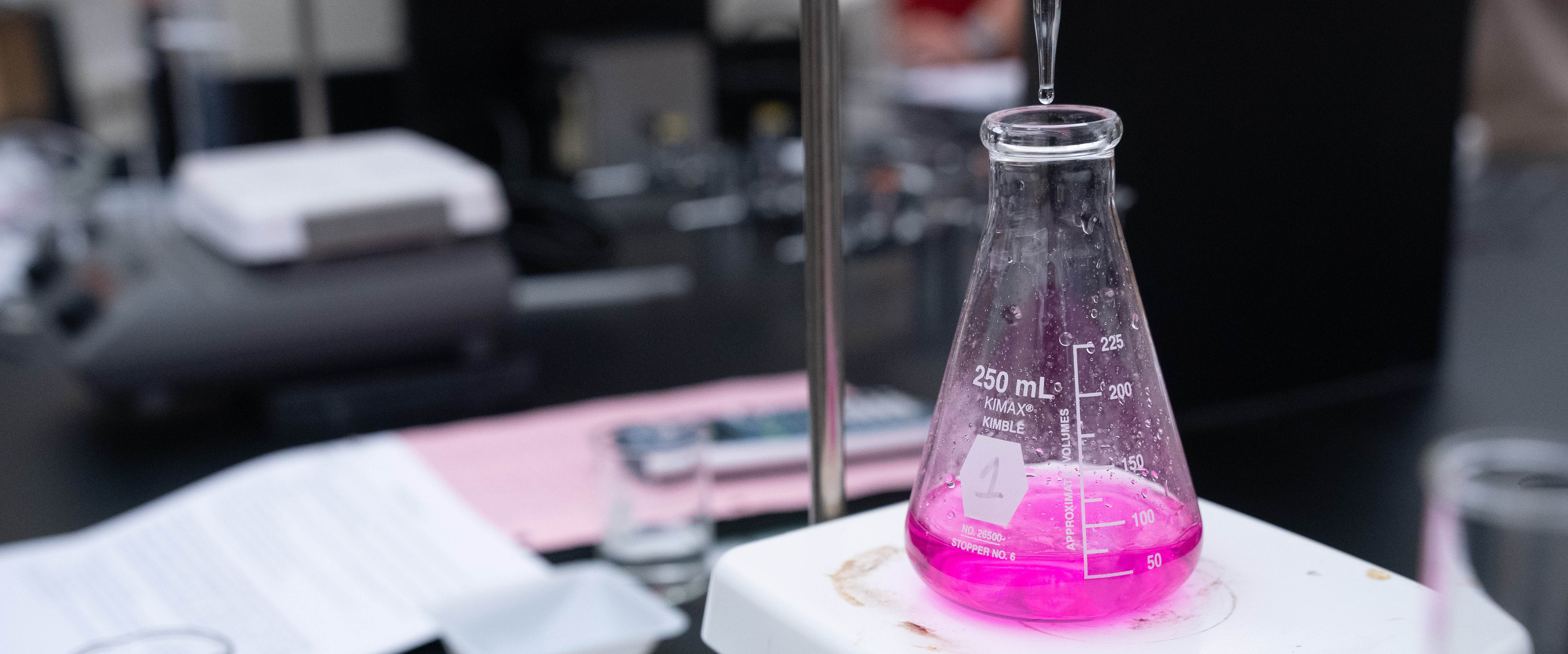 Close up of beaker filled with a pink liquid