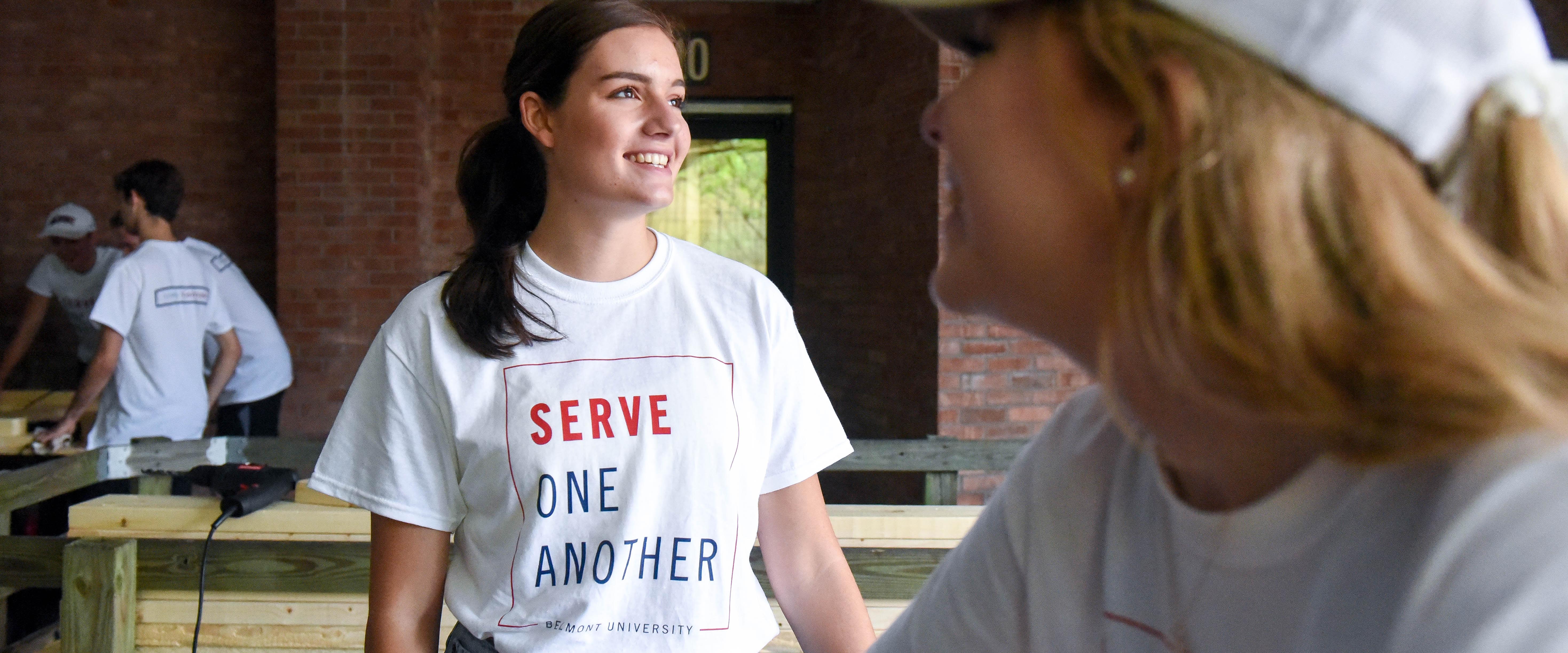 2 Students smiling while volunteering during SERVE for Towering Traditions