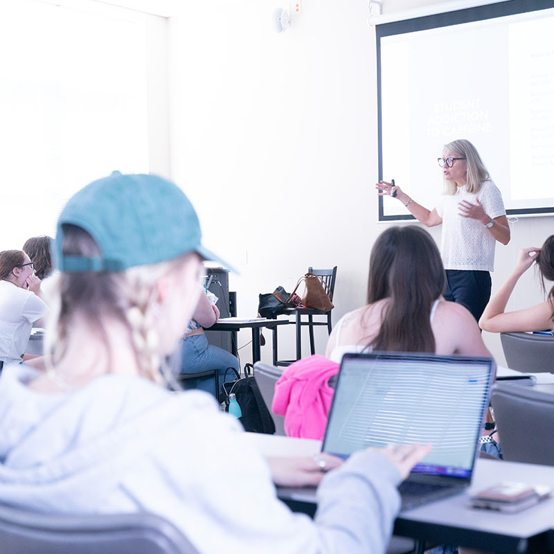 A student taking notes on a laptop during a journalismclass