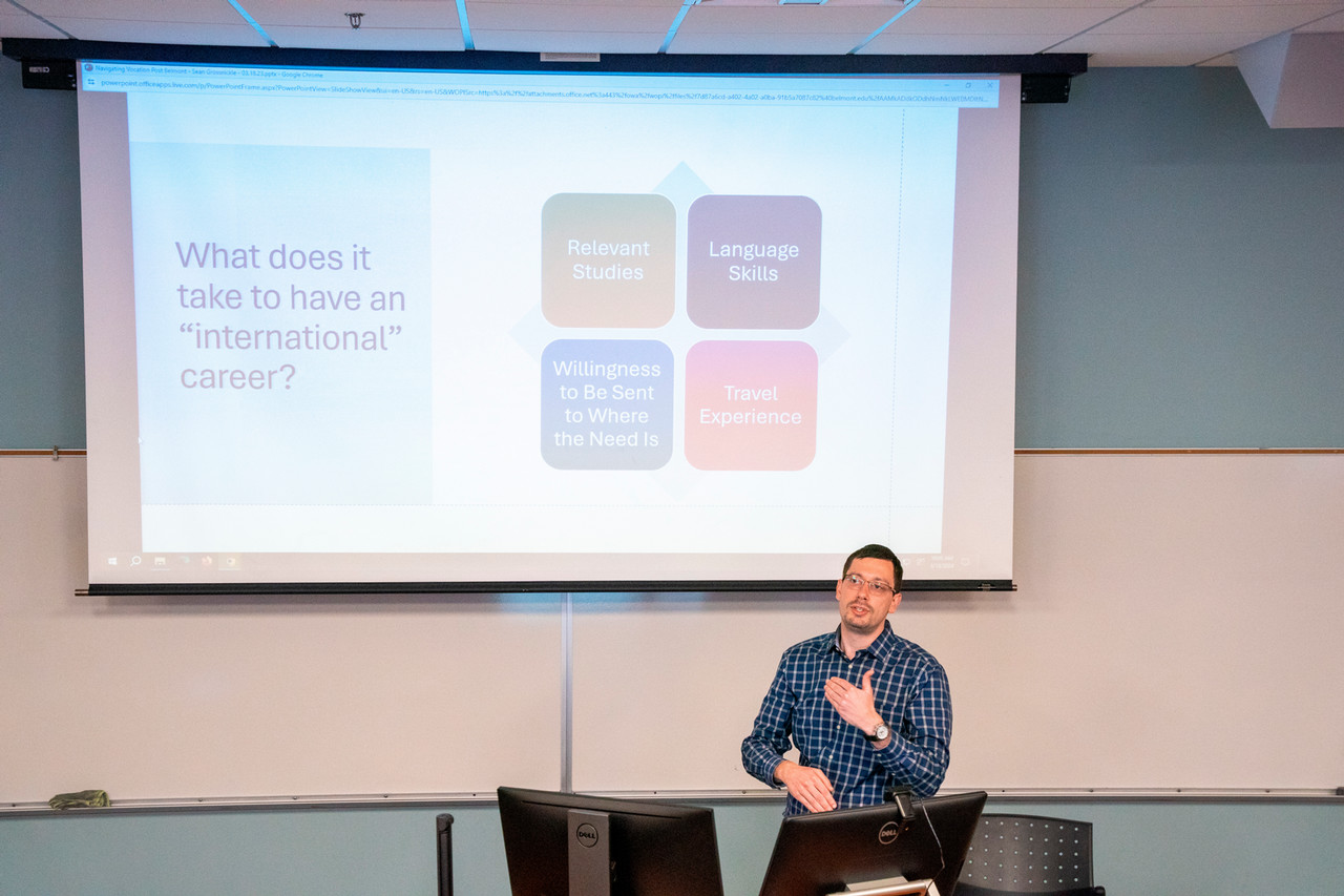 Sean Grossnickle stands in front of a slide while presenting to students