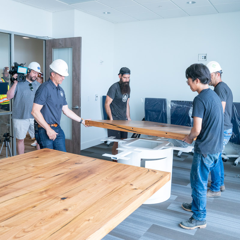 Moving final piece of table top into Massey Center conference room.