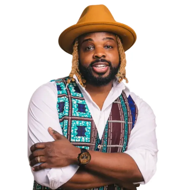 Fyutch dressed in a white button down, patterned vest, and a brown hat.