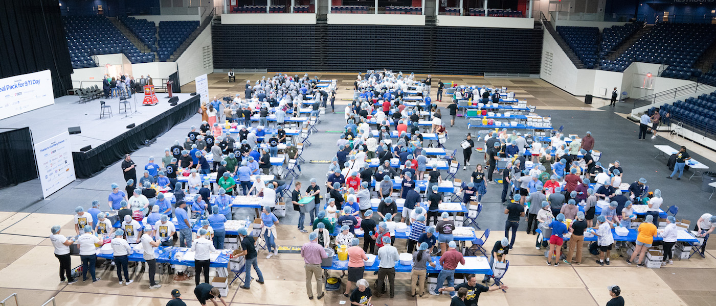 volunteers fill the floor to pack meals