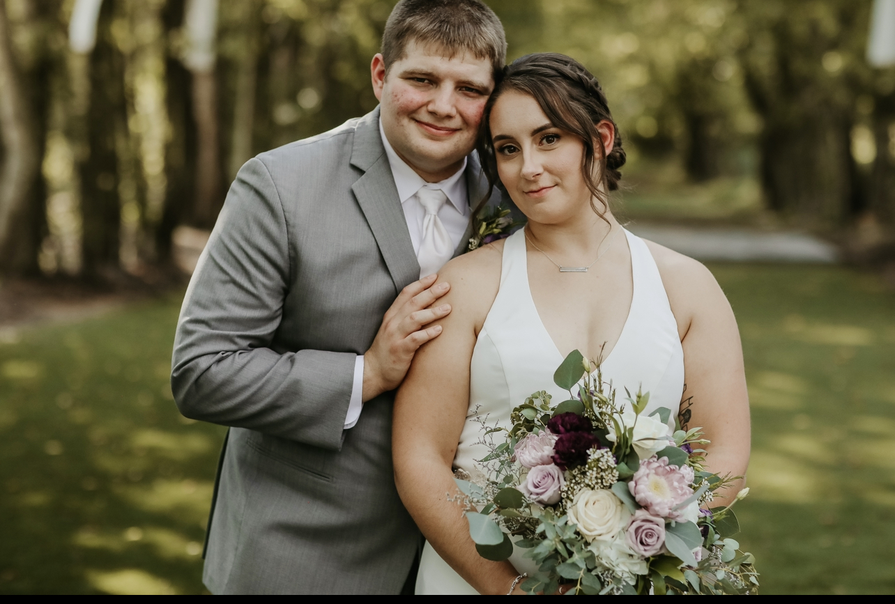 Smith in wedding dress and bouquet with husband, Brandon Smith, in 2022