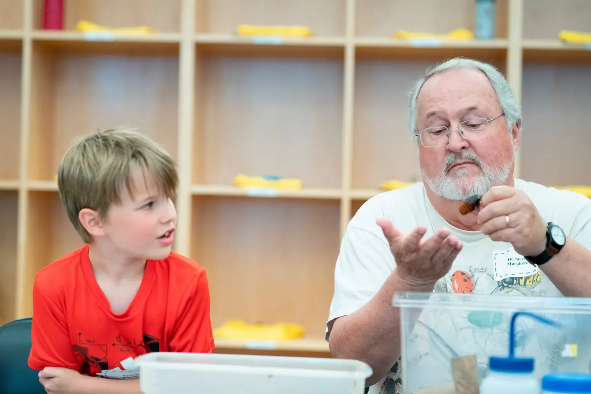 Dr. Muphree holds a cockroach