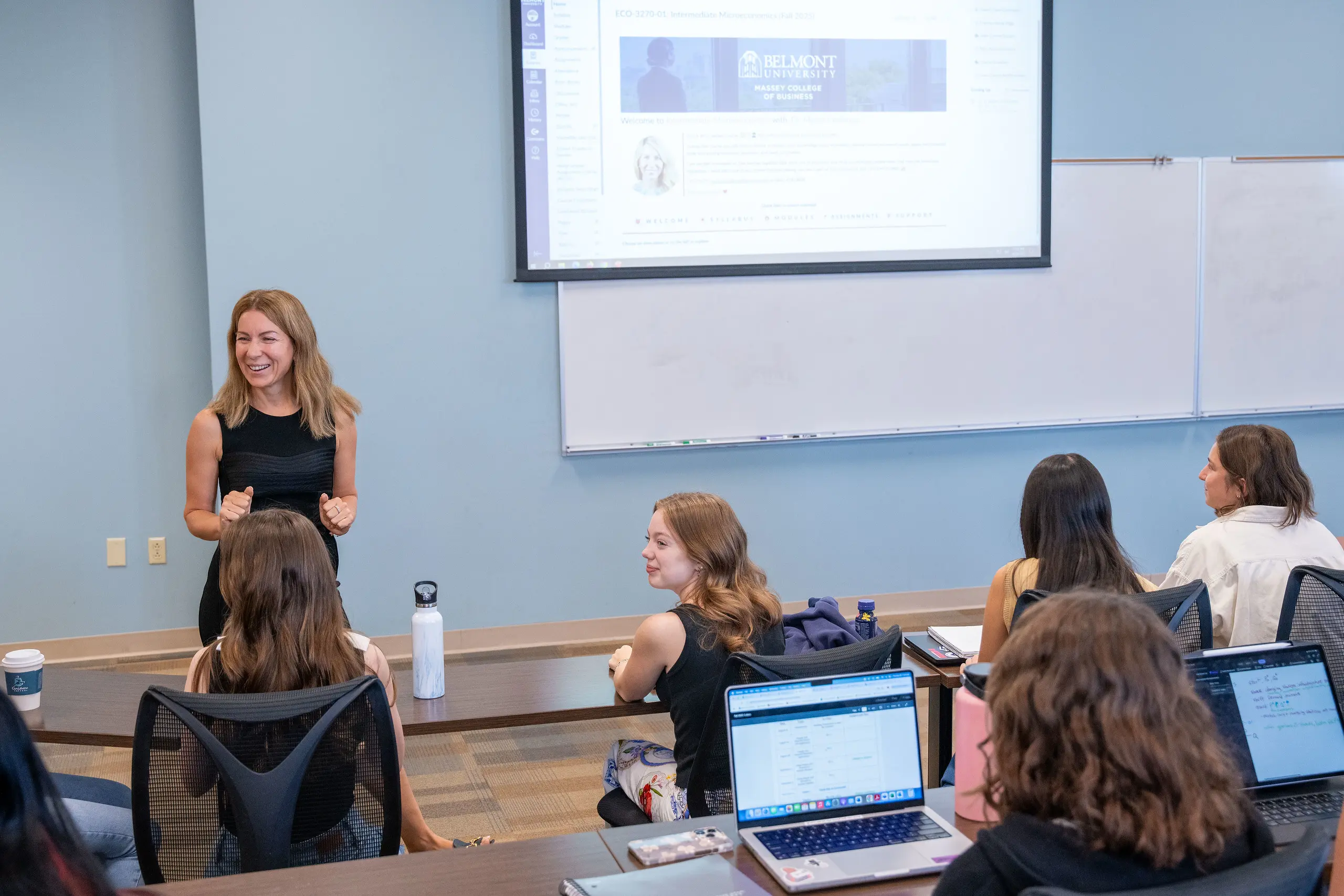 Students listening to an economics lecture in a gray room