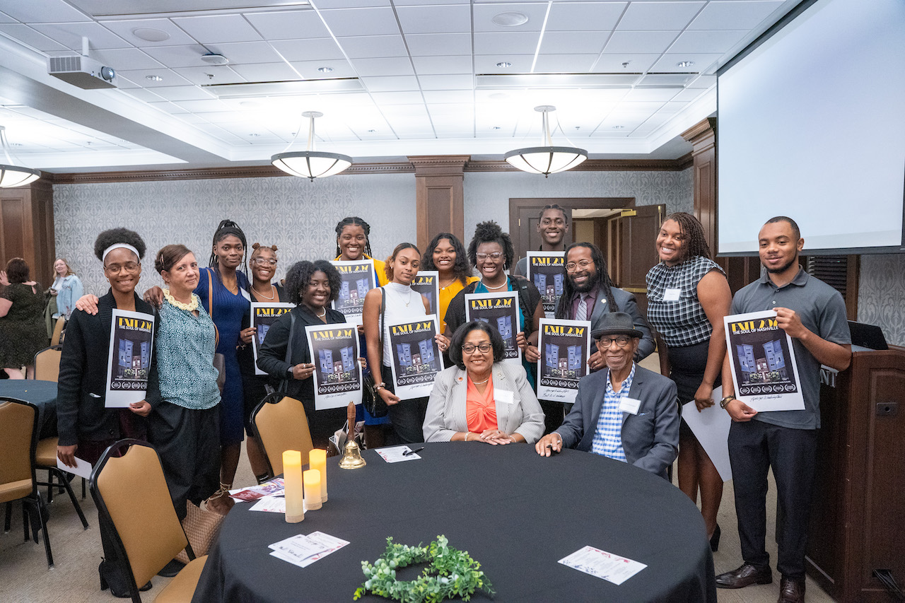 Attendees pose with Exit 207 posters signed by Lorenzo Washington